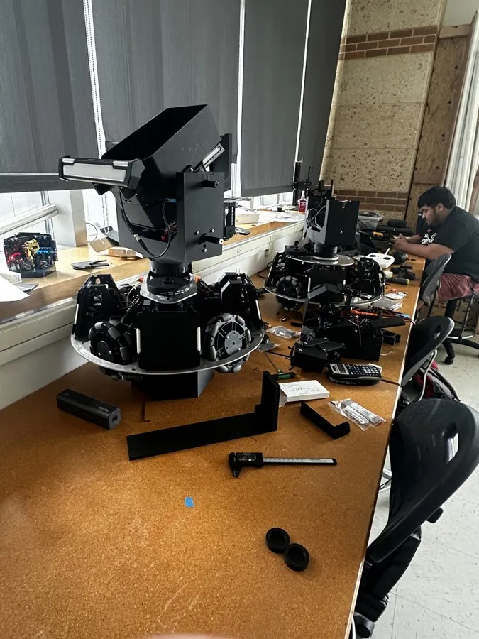 Multiple robots in various stages of assembly on the workbench