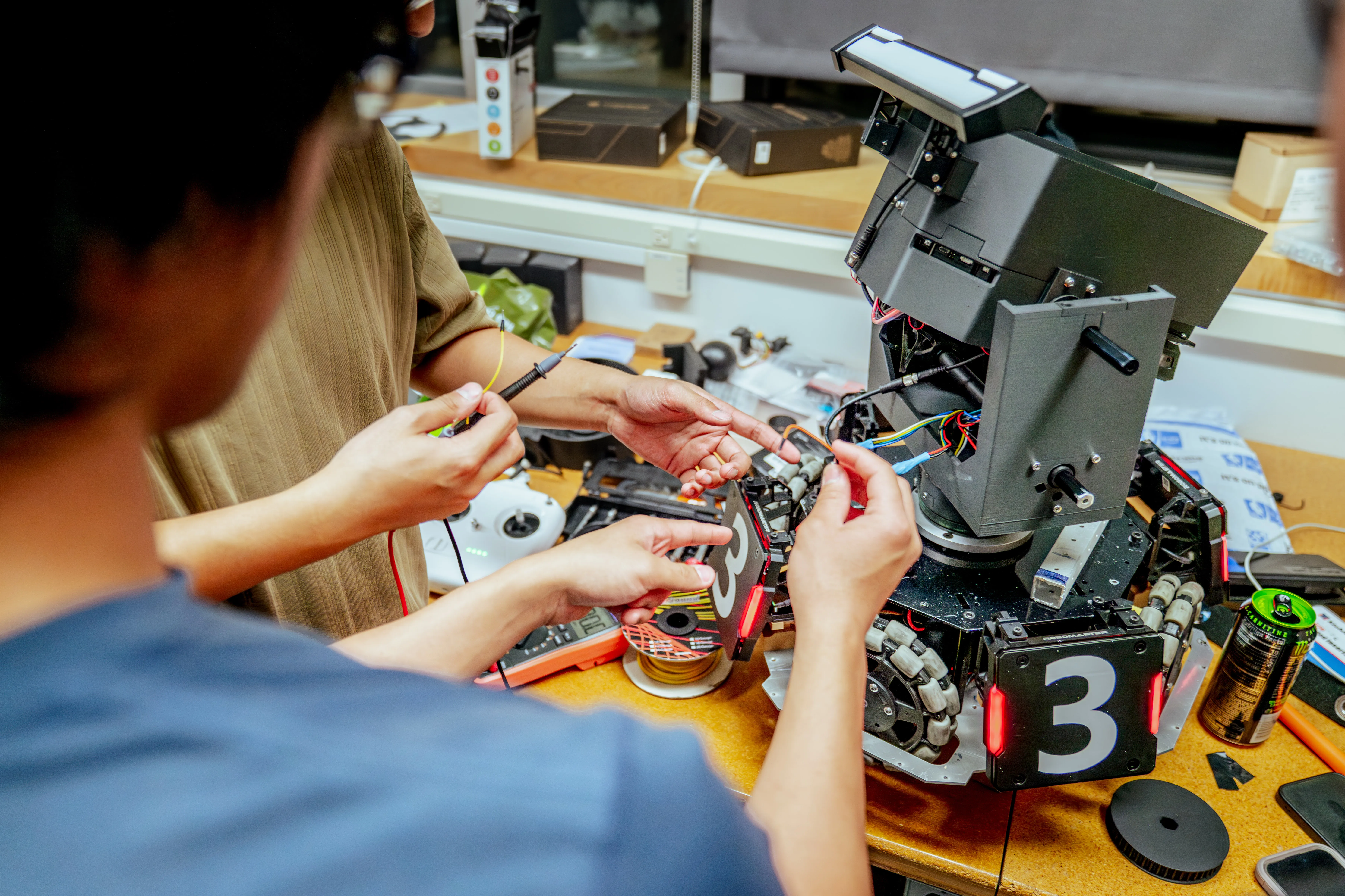 Team members assembling the turret section of a competition robot